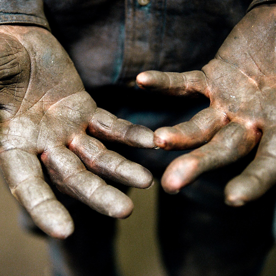 Close-up of a worker’s weathered, grease-stained open hands