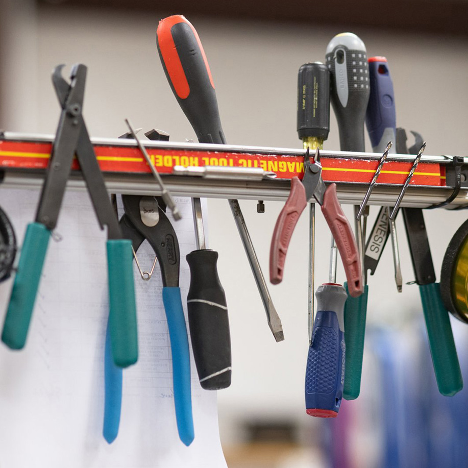 Pliers and screwdrivers hanging from a magnetic tool bar