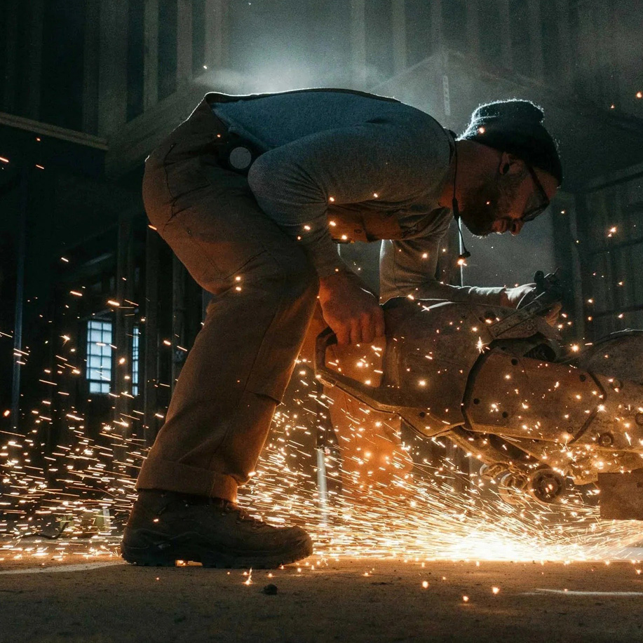 A worker grinding metal in a shower of sparks